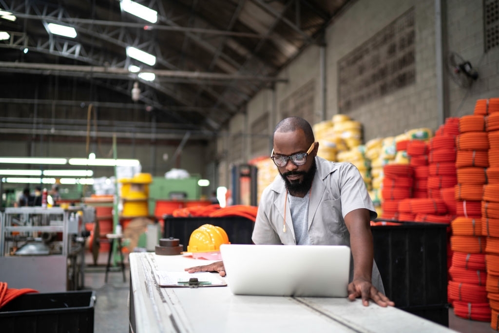 Engineer working at the factory using laptop